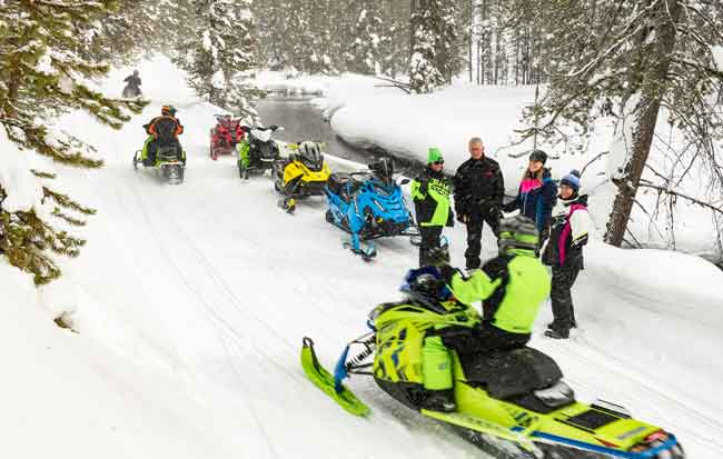 Snowmobilers along a river, Polaris, Arctic Cat, Ski-Doo, Yamaha