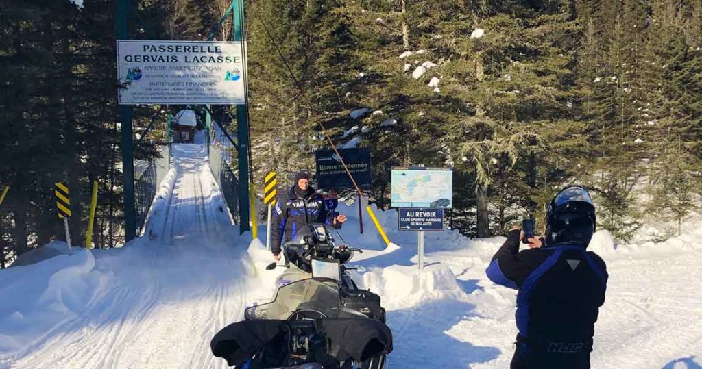 Backpack snowmobiling the Gasp Quebec. Passerelle Gervais Lacasse Bridge.