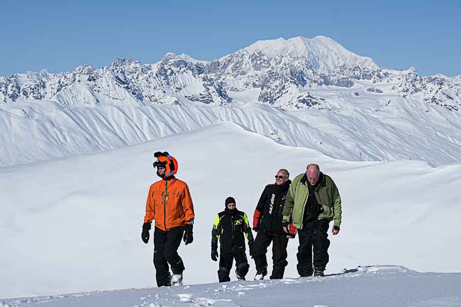 Randy Bedard, JP Bernier, Roger Wright and Chris Gamache check an alternate route from atop a ridge while on a snowmobile trip in Alaska.