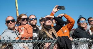 Spectators at NH Grass Drags and Watercross watch snowmobile race in Fremont where RAVE X performed freestyle snowmobile stunts.