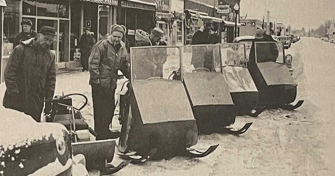 Polaris snowmobile display on Main St in Roseau, Minnesota. David Johnson, Allan Hetteen and Edgar Hetten show the public the new Sno-Traveler machines. Photo from the book Breaking Trail.